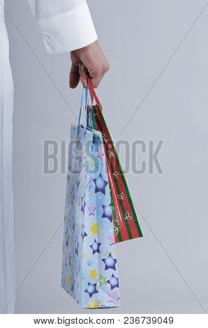 Hand Holding Shopping Bags With Gifts
