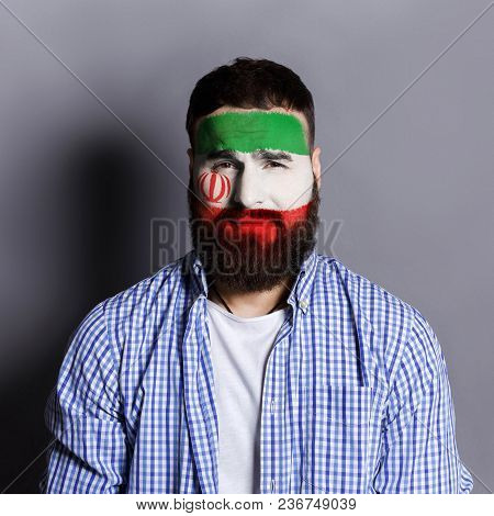 Face Of Young Man Painted With Flag Of Iran. Football Or Soccer Team Fan, Sport Event, Faceart And P