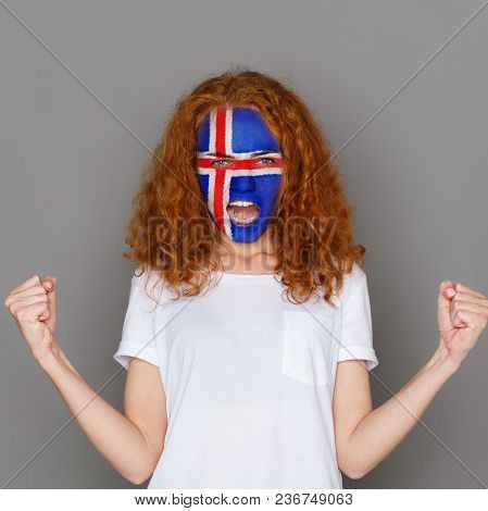 Face Of Young Screaming Woman Painted With Flag Of Iceland. Football Or Soccer Team Fan, Sport Event