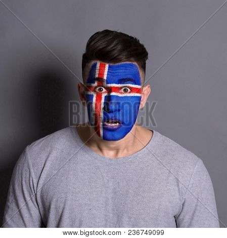 Face Of Young Man Painted With Flag Of Iceland. Football Or Soccer Team Fan, Sport Event, Faceart An