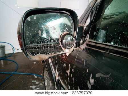 Car Wash. Soap Foam Removed Dirt From The Side Mirror