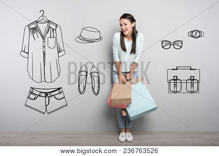 Pleasant Shopping. Cheerful Emotional Young Girl Feeling Happy While Standing With Paper Bags After 