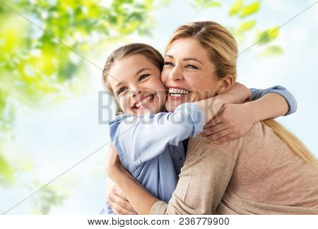 people and family concept - happy smiling mother hugging daughter over green natural background