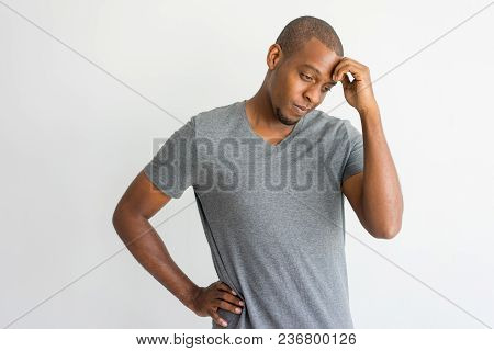 Puzzled Handsome African Man Having Problems. Upset Thoughtful Young Man In T-shirt Touching Forehea