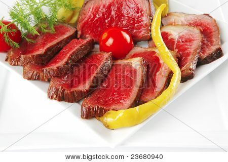 半生的牛肉肉与蔬菜在白板上