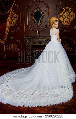 Full length portrait of a beautiful bride woman in luxurious white wedding dress. Luxurious vintage apartments. Wedding fashion.
