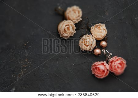 Mix Of Fake Plastic Mini Rosess Pink And Peach Color Earings Black Round Plate Copy Space.