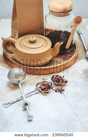 Ceramic Tea Pot, Metal Tea Infuser And Cup Of Black Tea. Composition With Tea Accessories On A White