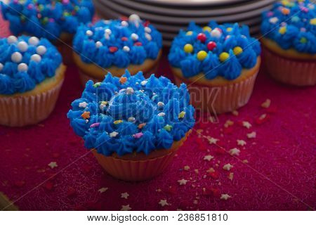Colorful Cupcakes With Different Tastes. Small Beautiful Cakes On Red Table Top. Close Up