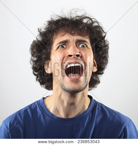 Angry Man Screaming At Somebody. Expressive Young Man