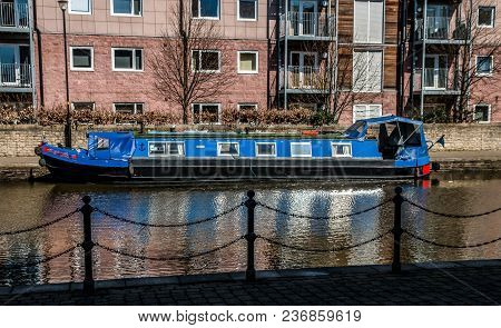 A Small Royal Blue Barge Moored Up On The Towpath Of The Leeds Liverpool Canal In Wigan