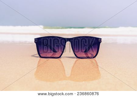 Close-up Of Seashells, Straw Hat, Glasses That Lie On The Sea Sand,