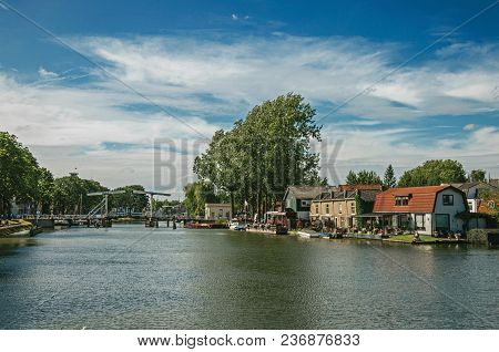 Vecht River With Bridge, Boats On The Banks And Brick Houses On A Sunny Day In Weesp. Quiet And Plea