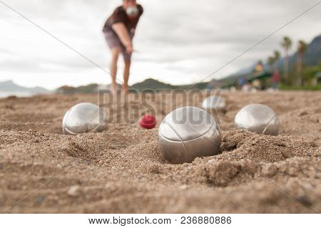 Beach. A Game Of Bocha. Brilliant Silver Balls For A Bocha On The Sand.