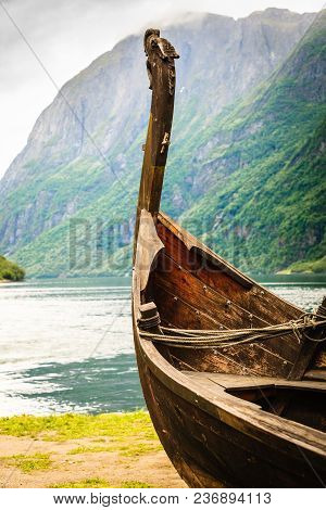 Old Wooden Viking Boat On Seashore In Norwegian Nature. Mountains And Fjord Sognefjord. Tourism And 