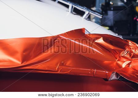 Car Wrapping Specialist Putting Vinyl Foil Or Film On Car. Selective Focus.