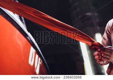 Car Wrapping Specialist Putting Vinyl Foil Or Film On Car. Selective Focus.