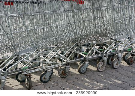 A Row Of Gray Shopping Carts From A Supermarket Stand On The Street