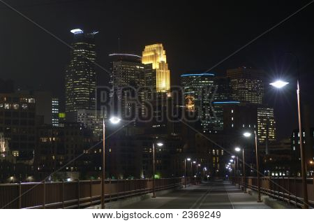 Minneapolis City Skyline ser på tværs af stenen bue broen om natten