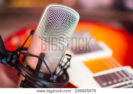 Microphone In Home Recording Studio With Red Guitar On Background