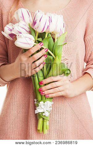 Young, Beautiful Girl Is Holding Spring Flowers In The Studio. Tulips. Portrait On White Background