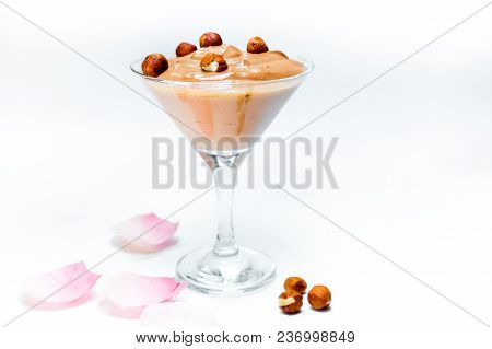 Brown Chocolate Ice Cream In A Transparent Glass Bowl With Nuts.