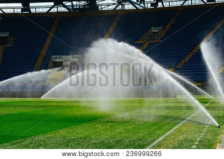 Irrigation Turf. Sprinkler Watering Football Field. System Working On Fresh Green Grass On Football