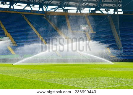 Irrigation Turf. Sprinkler Watering Football Field. System Working On Fresh Green Grass On Football