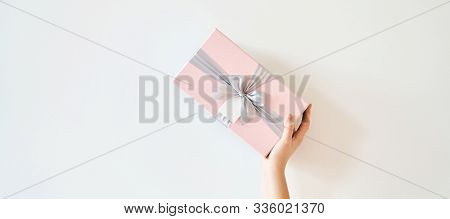 A Girl Holds A Gift Box On A White Background. Banner, Copy Space.