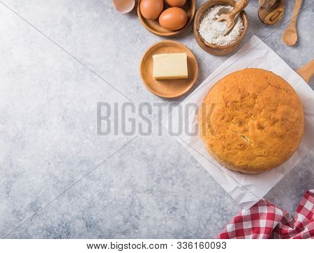 Homemade  Soft And Lite Delicious Sponge Cake With Ingredients: Eggs Flour Milk On Stone Concrete Ta