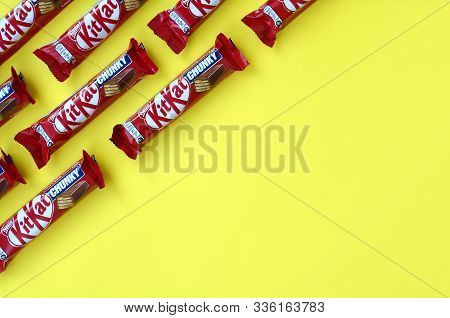 Kit Kat Chocolate Bars In Red Wrapping Lies On Yellow Background. Kit Kat Created By Rowntrees Of Yo