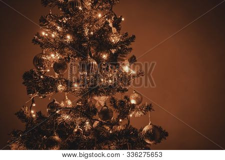 Photo Of A Christmas Tree With Bronze Christmas Lights And Christmas Ornaments. Space For Copy Or Te