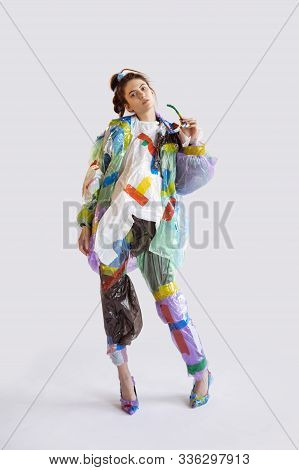 Woman Wearing Plastic On White Background. Female Model In Clothes And Shoes Made Of Garbage. Fashio