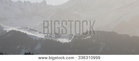 An Alpine Landscape With A Forest Ridge In Winter