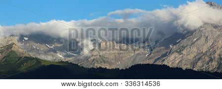 View Of A Forest Ridge And Mountain Wall With Clouds In Summer
