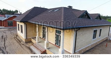 House With A Roof From A Bituminous Tile. Bituminous Tile For A Roof. A Roof From A Bituminous Tile.