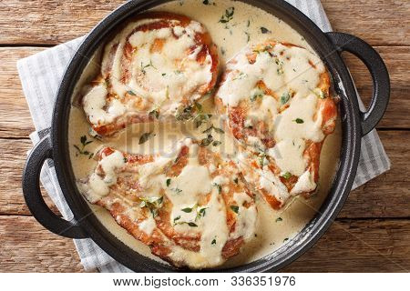 Boneless Pork Chops Served In Creamy Wine Sauce With Herbs Close-up In A Pan. Horizontal Top View