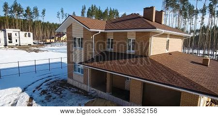 House With A Roof From A Bituminous Tile. Bituminous Tile For A Roof. A Roof From A Bituminous Tile.