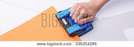 Panoramic Shot Of Woman Using Holepunch On White Background
