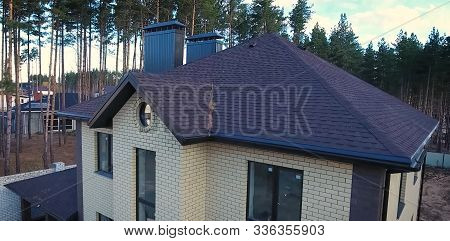 House With A Roof From A Bituminous Tile. Bituminous Tile For A Roof. A Roof From A Bituminous Tile.