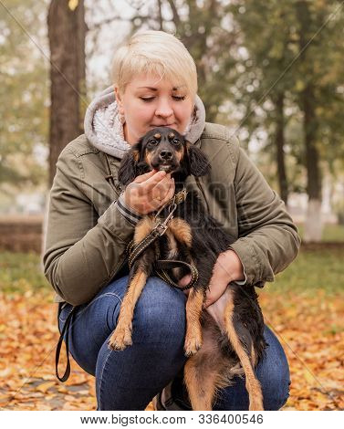 Pet Care Concept. Woman Hugging Her Mixed Breed Dog In An Autumn Park