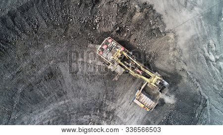 Cable Excavator Loads Overburden From The Body Of A Mining Truck. Excavation Of Gangue From The Face