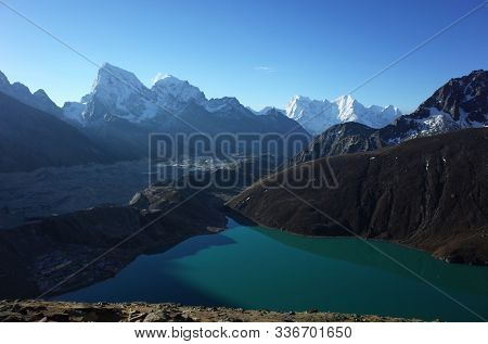 Hiking in Nepal Himalayas, View of Gokyo lake, Ngozumba glacier, Arakam Tse and Cholatse mountain. High altitude glacier lake in mountains early morning at sunrise