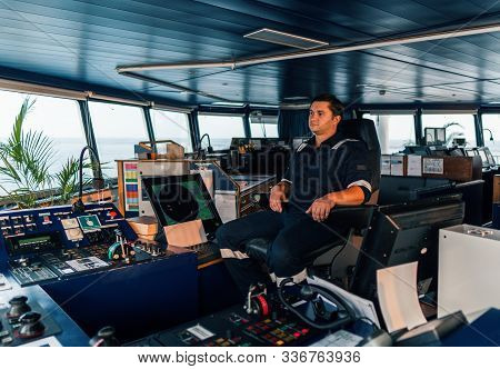 Marine Navigational Officer During Navigational Watch On Bridge . Work At Sea
