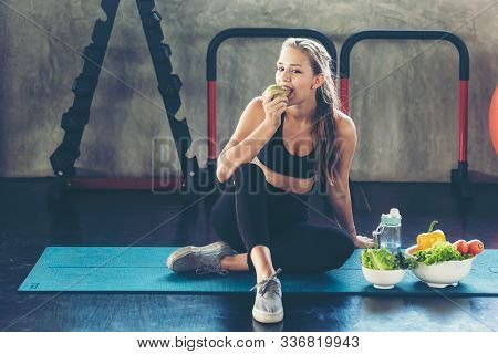 Lifestyle Women Eating Green Apple And Fresh Salad After Exercise  At The Gym Workout For Healthy Ca