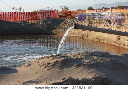 Work In Progress On The Sandy Beach. Open Yard, Between Pipes And Orange Bars Before The Seasonal Su