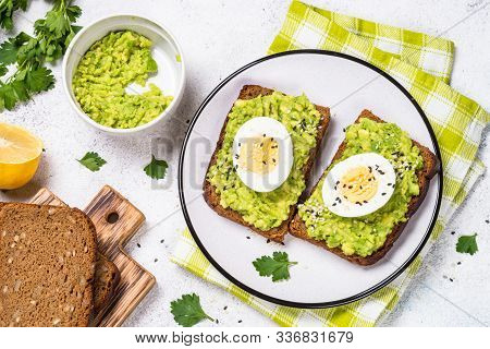 Avocado Sandwiches With Boiled Egg And Cereal Bread On White Background, Top View.