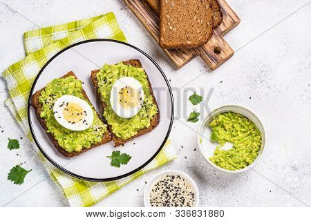 Avocado Sandwiches With Boiled Egg And Cereal Bread On White Background, Top View.