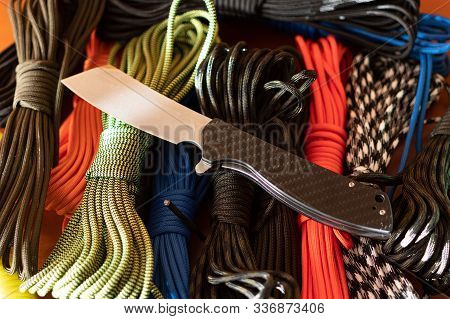 Pocket Knife And Multi-colored Ropes. Folding Knife And Paracord. Multi-colored Ropes.