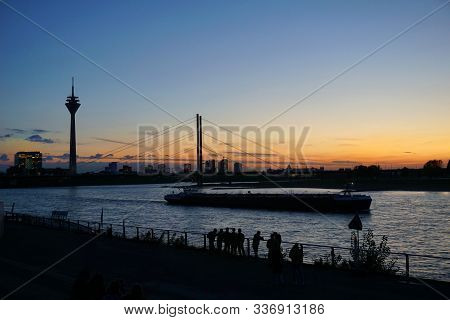 Düsseldorf, 29 October 2019. People Admiring The Dusseldorf Skyline With Rheinturm At Sunset. Romant